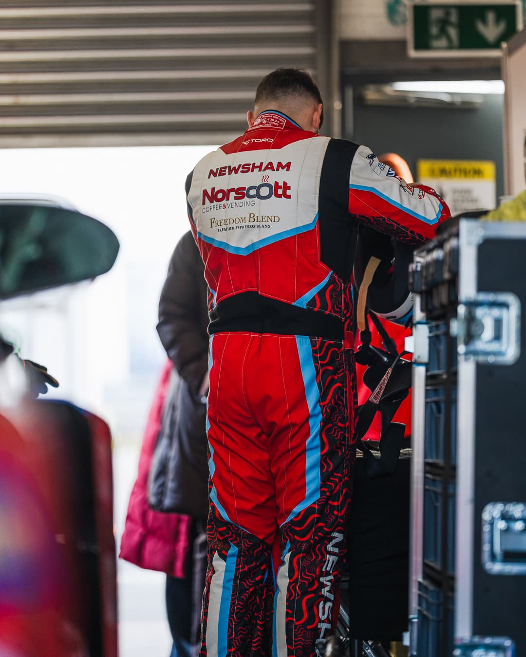 Callum Newsham gearing up in the garage wearing his bespoke Racecraft suit